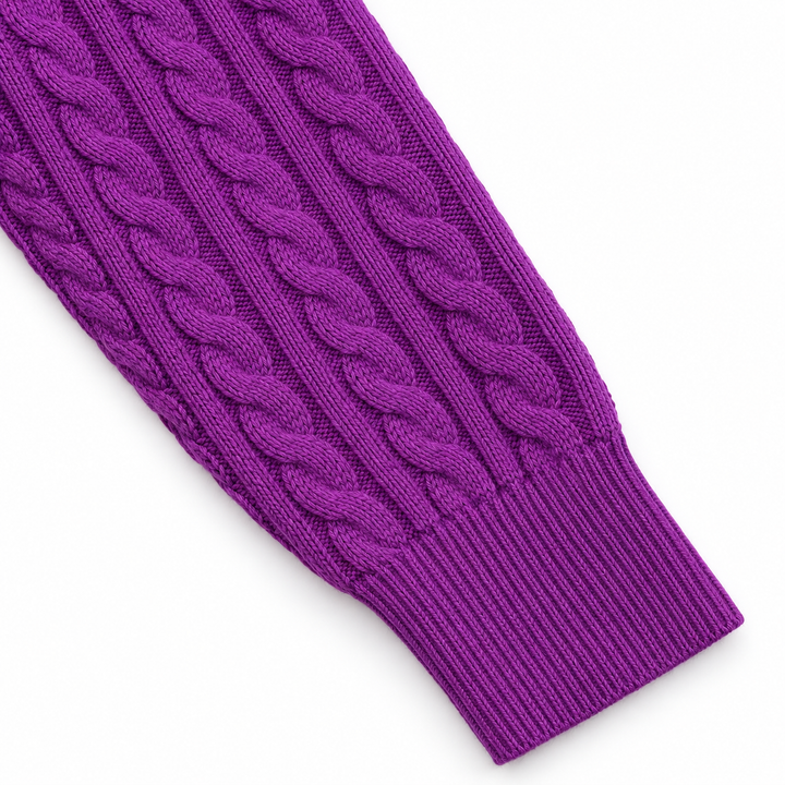 Purple sweater sleeve detail close-up showing cable knit pattern and ribbed cuff, arranged on a clean white studio background