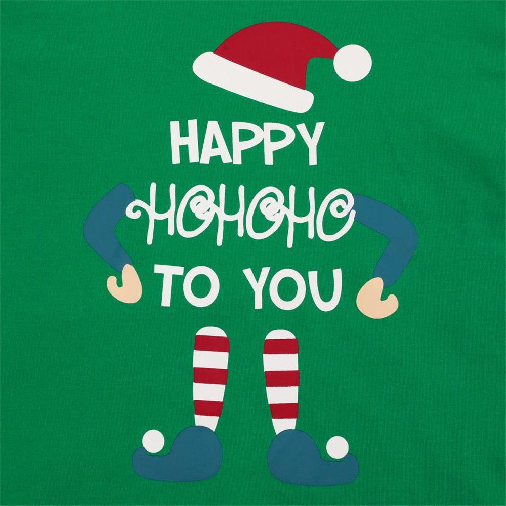 "family christmas pajamas set in green doll motif for cozy bedtime stories with siblings sitting on bed under fairy lights"