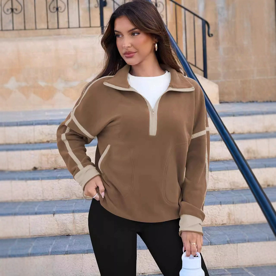 Woman wearing a brown and beige pullover standing on steps outdoors