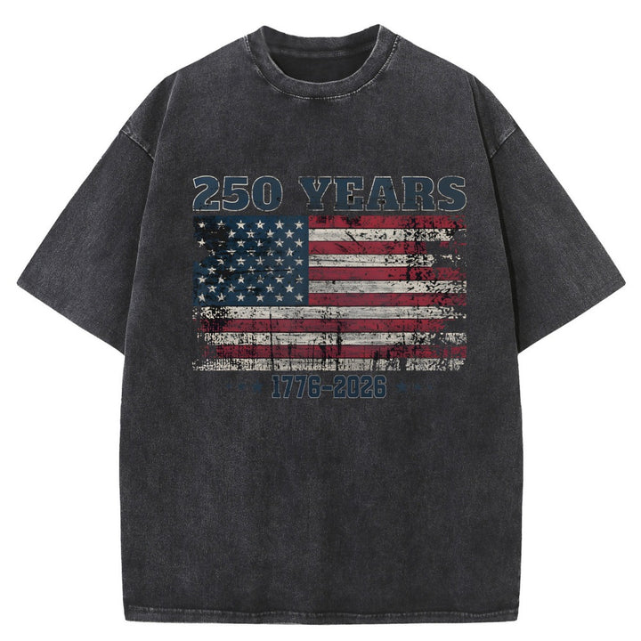 A dark gray acid-wash t-shirt featuring a distressed American flag graphic on the chest with &