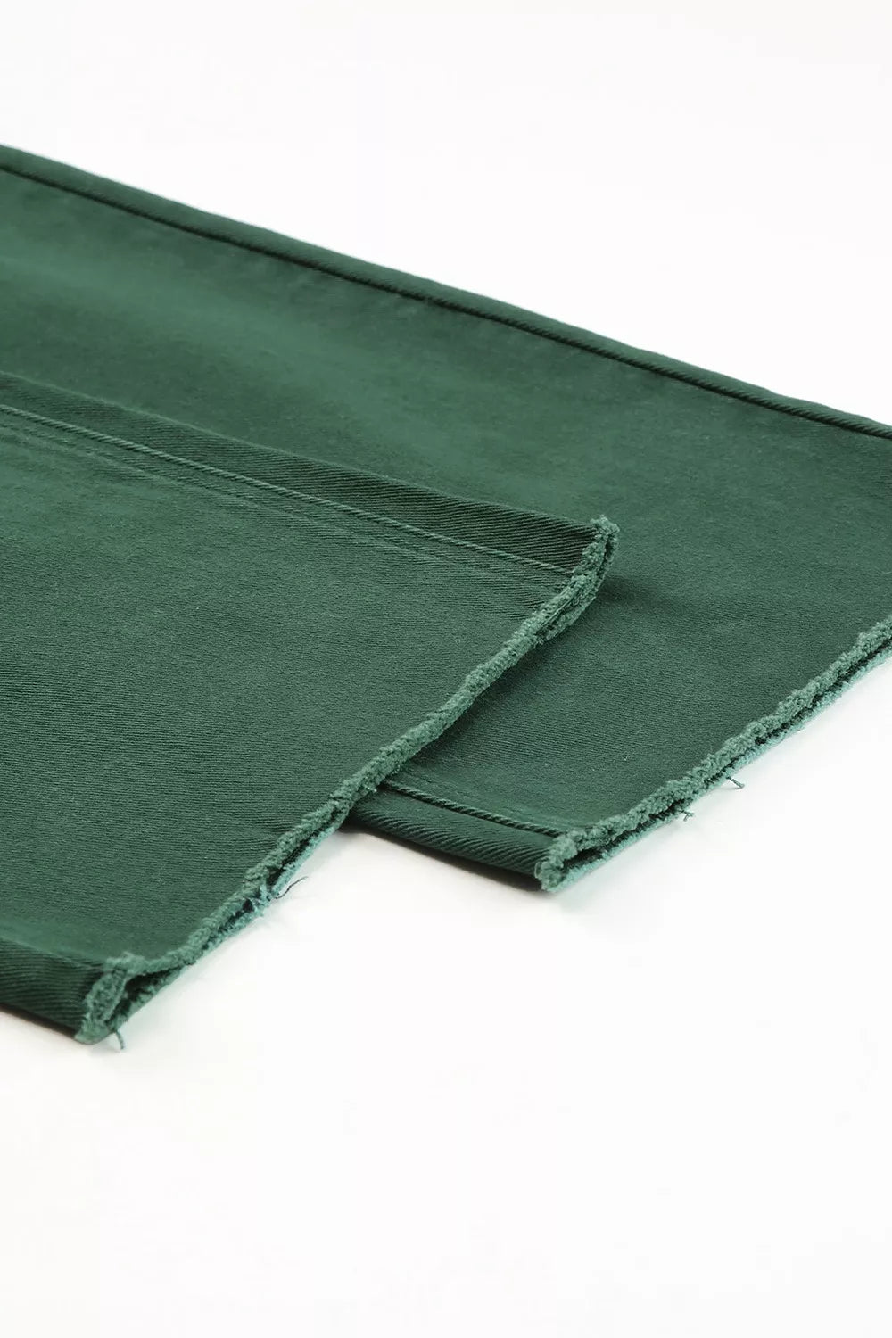 Green fabric with frayed edges on a white background