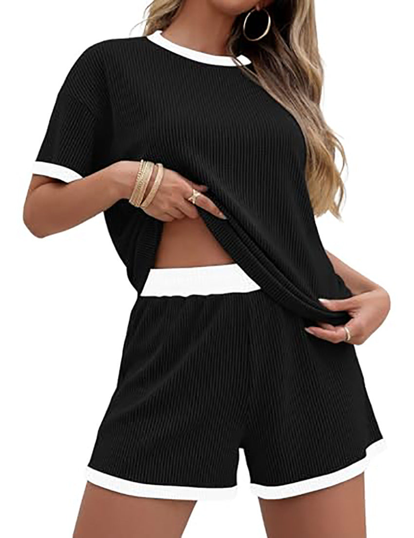 Woman wearing a black and white outfit with shorts and a top.