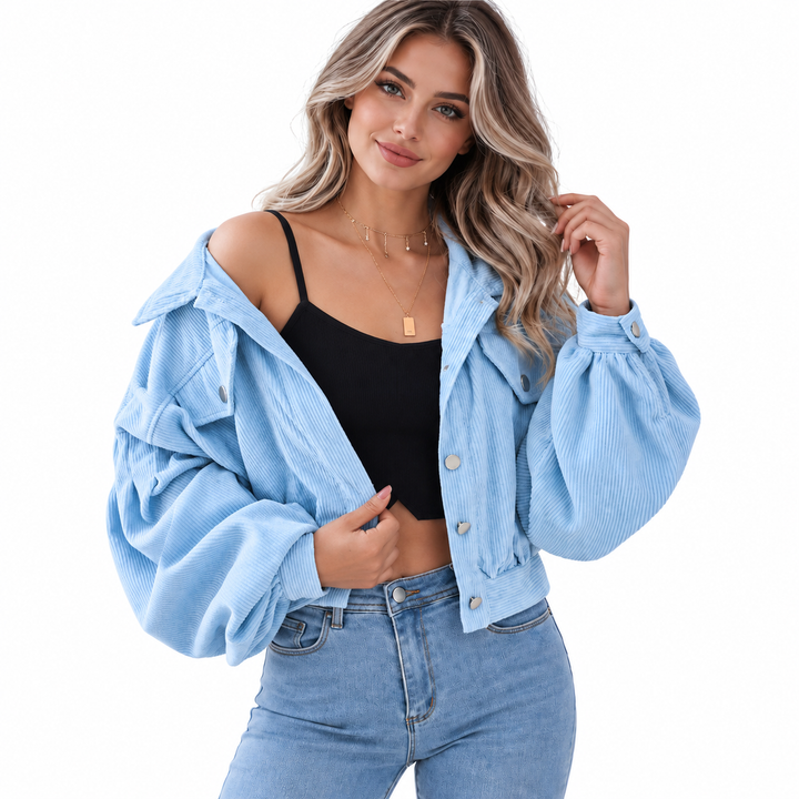 Denim Blue corduroy jacket on a female model with front button details and lantern sleeves, photographed on a clean white background.