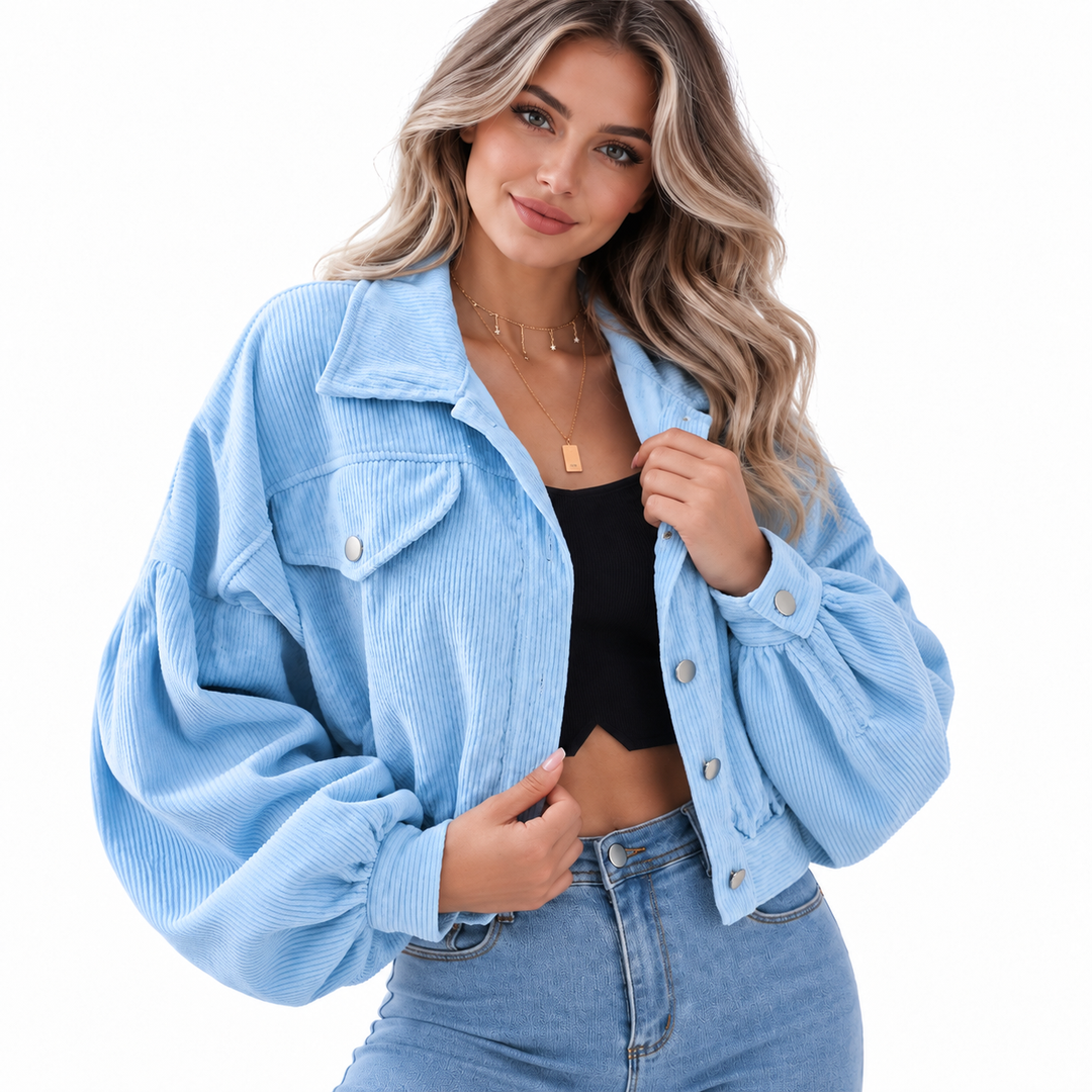Denim Blue cropped corduroy jacket on a model, showing the wide collar, front pockets and balloon-style sleeves on white background.