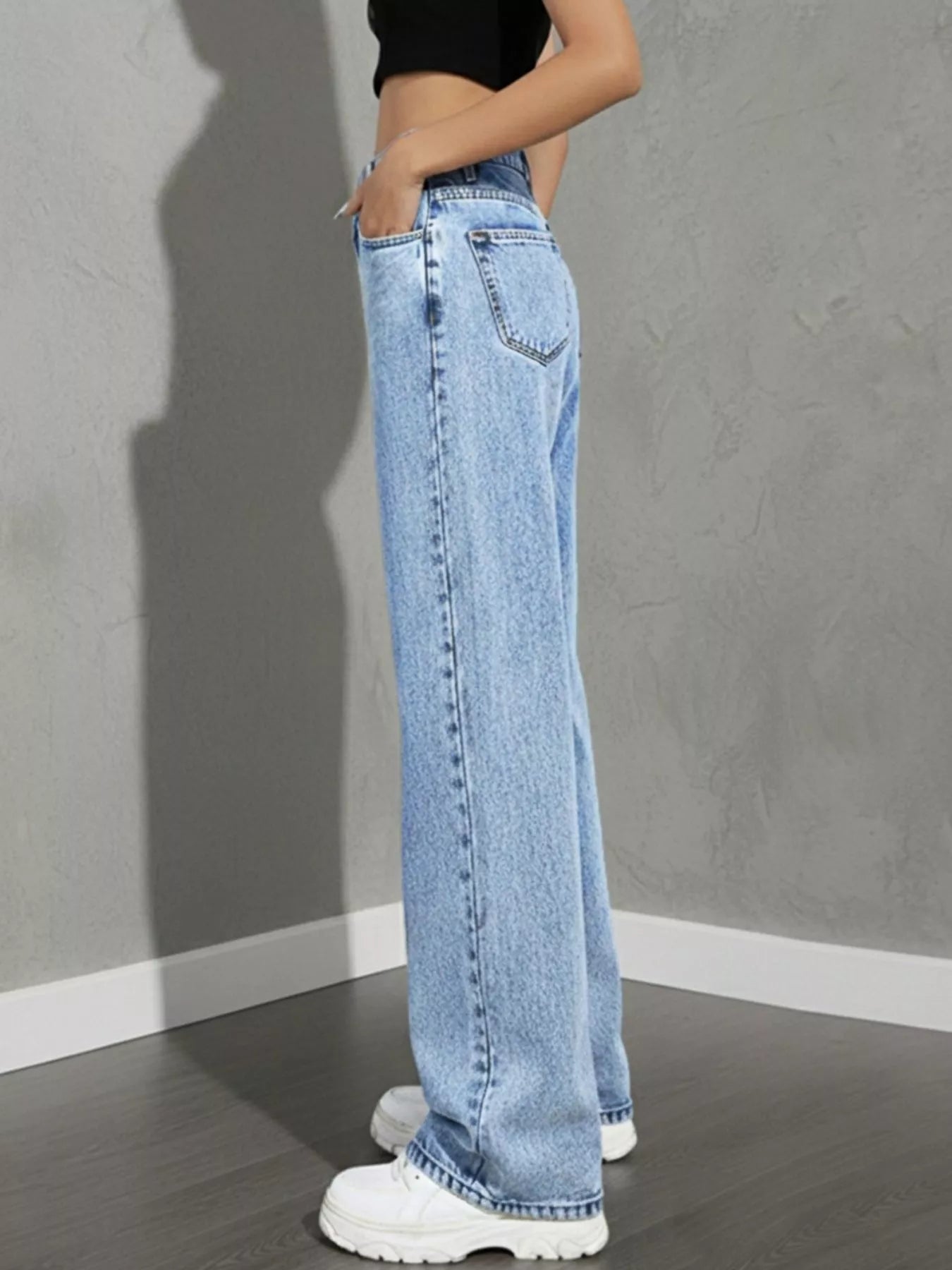 high rise wide leg jeans close-up of button closure and waistband stitching light wash rigid denim for structured fit
