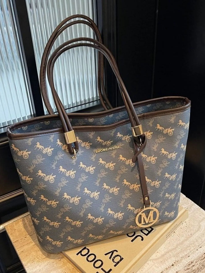 Printed tote shoulder bag on a white studio background with brown strap details visible.