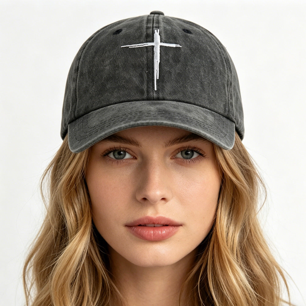 Person wearing a black baseball cap with a white cross on a white background