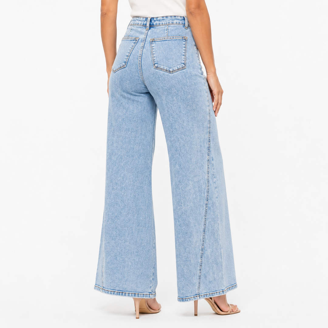 Light blue wide leg denim jeans side view showing skewed inseam detail, smooth high waist and full length relaxed leg fit now