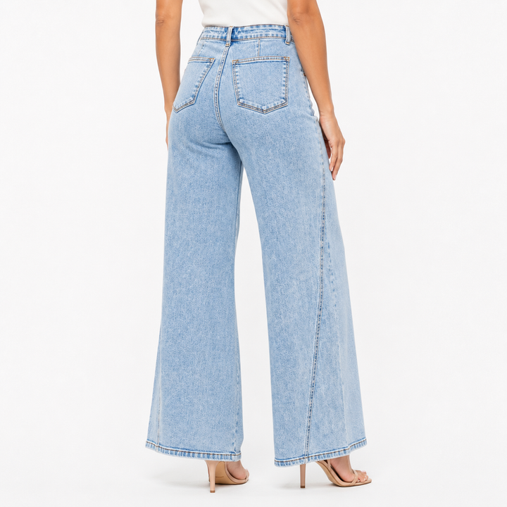 Light blue wide leg denim jeans side view showing skewed inseam detail, smooth high waist and full length relaxed leg fit now