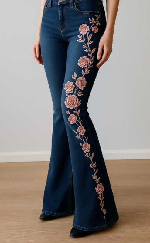 Dark blue flared jeans with dusty rose flowers and a trailing floral print down one leg.