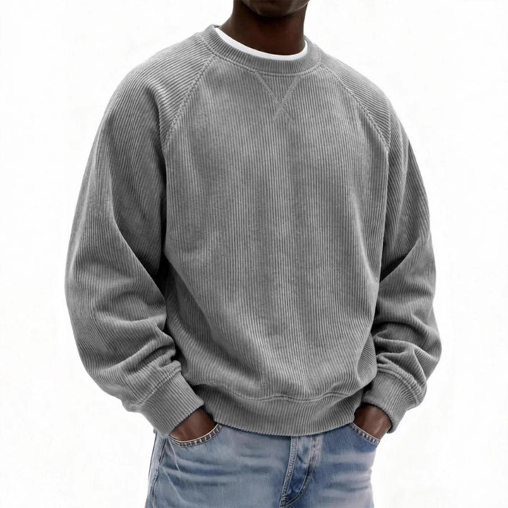 Person wearing a gray sweatshirt and blue jeans on a white background