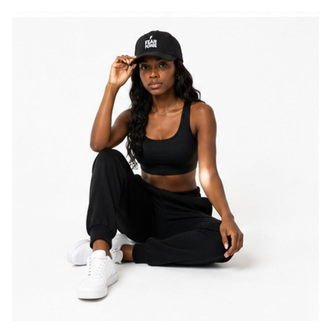 Fear None black denim cap styled on female model in relaxed studio pose