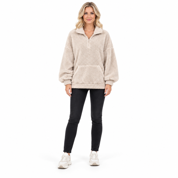 Beige fleece pullover on a second blonde model, shown from head to toe with dark jeans and trainers against a white backdrop.