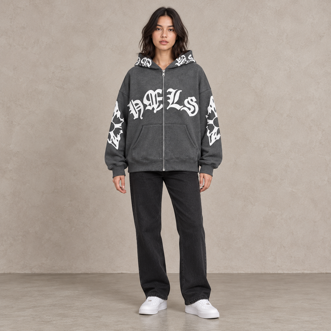 Full-body model wearing the dark gray Gothic print zip hoodie against a textured stone backdrop