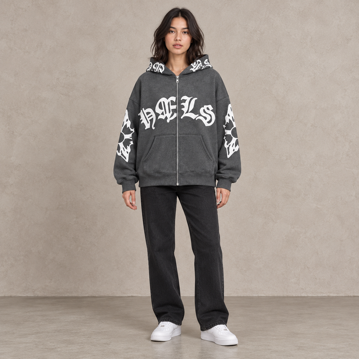 Full-body model wearing the dark gray Gothic print zip hoodie against a textured stone backdrop