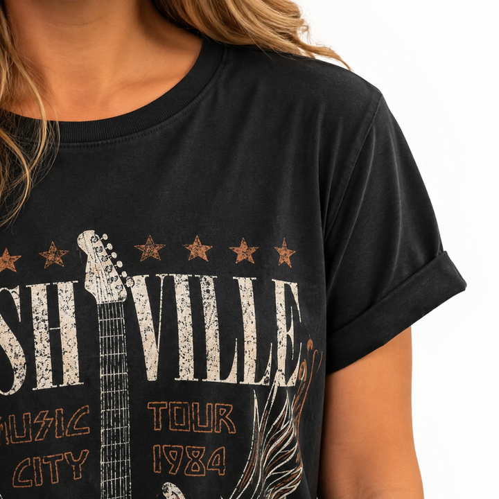 Close view of the round neckline, short sleeve edge and distressed Nashville print on the black tee dress.