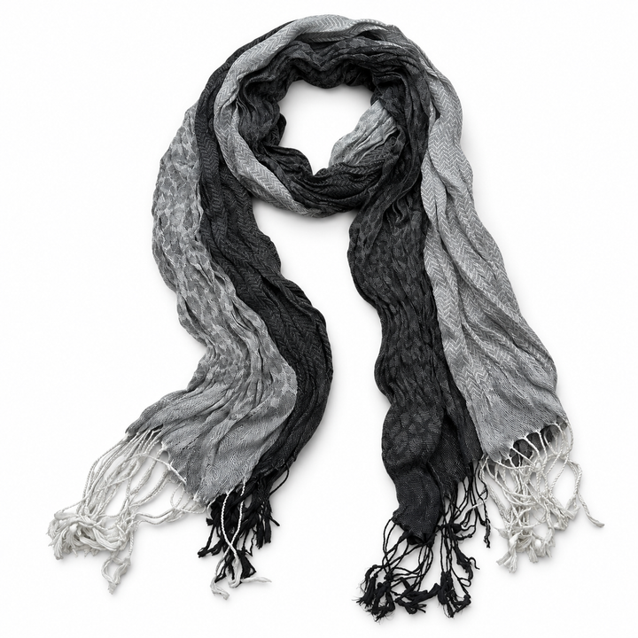 Grey scarf in a long grey-and-black jacquard pattern with fringed ends on white.
