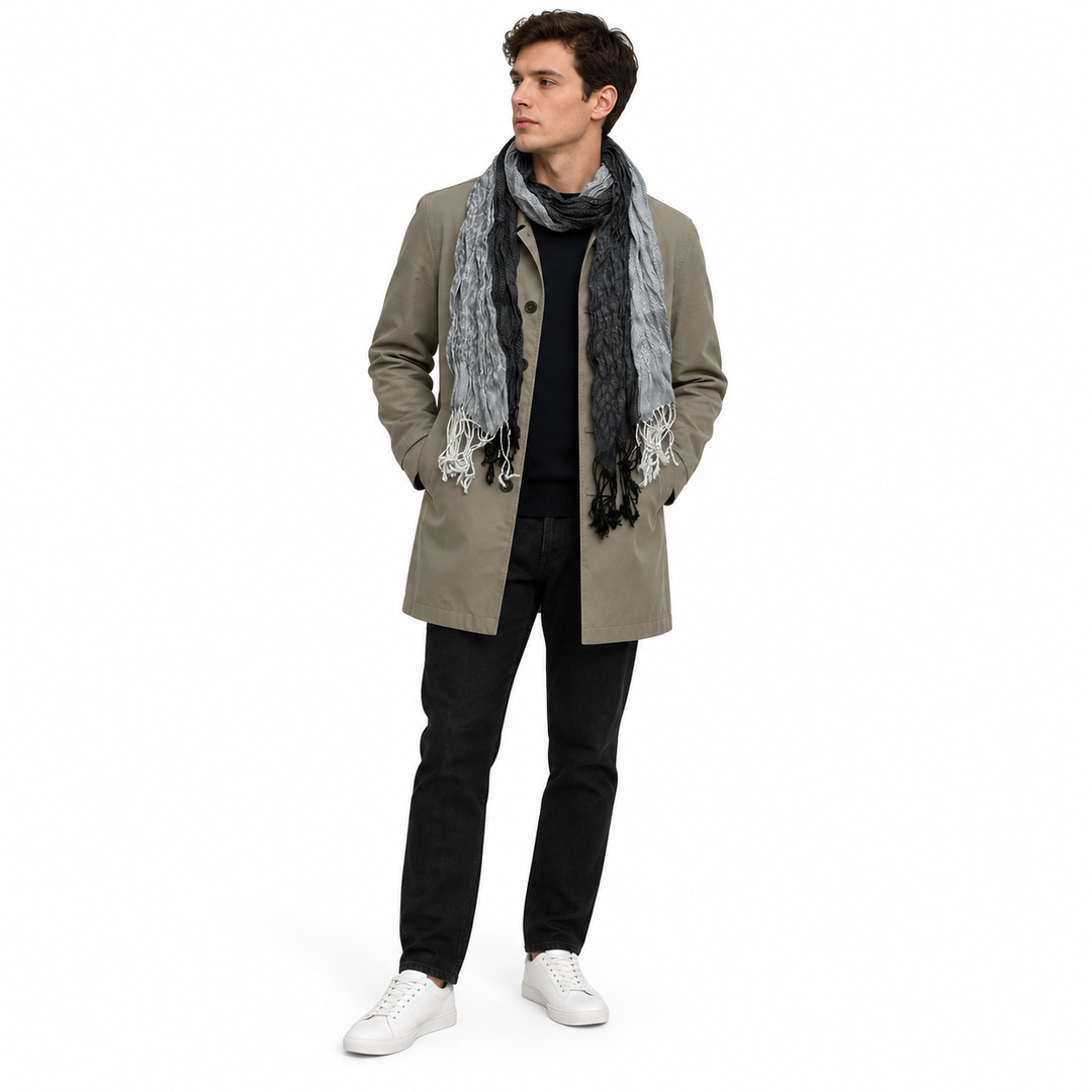 Adult man wearing the long jacquard scarf with a neutral coat, full body visible.