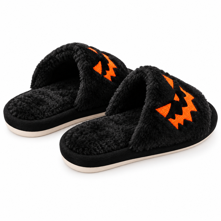 Black plush Halloween slippers with orange pumpkin faces, side three-quarter view