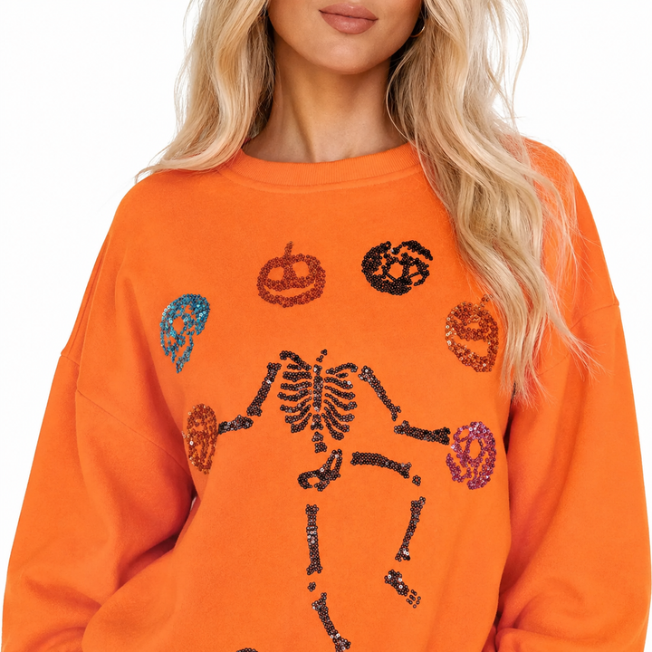 Close-up of orange Halloween Skeleton Pumpkin sweatshirt showing crew neck, fabric and sequin skeleton pumpkin details