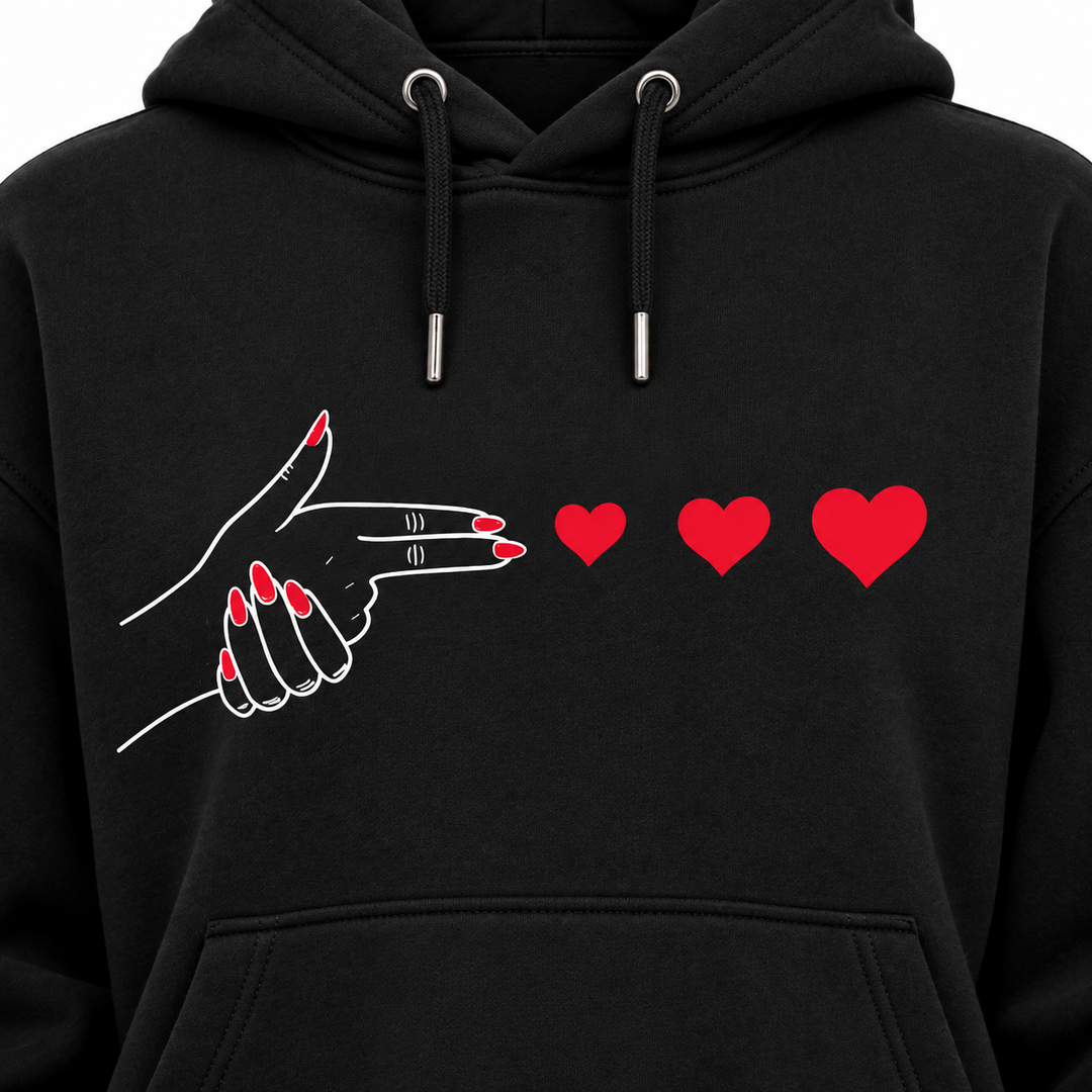 Close-up of hand and red heart print on black hoodie chest