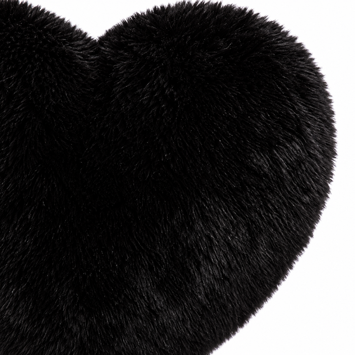 Close-up of the black plush heart bag showing the textured exterior, stitched center and curved top of its heart-shaped body.