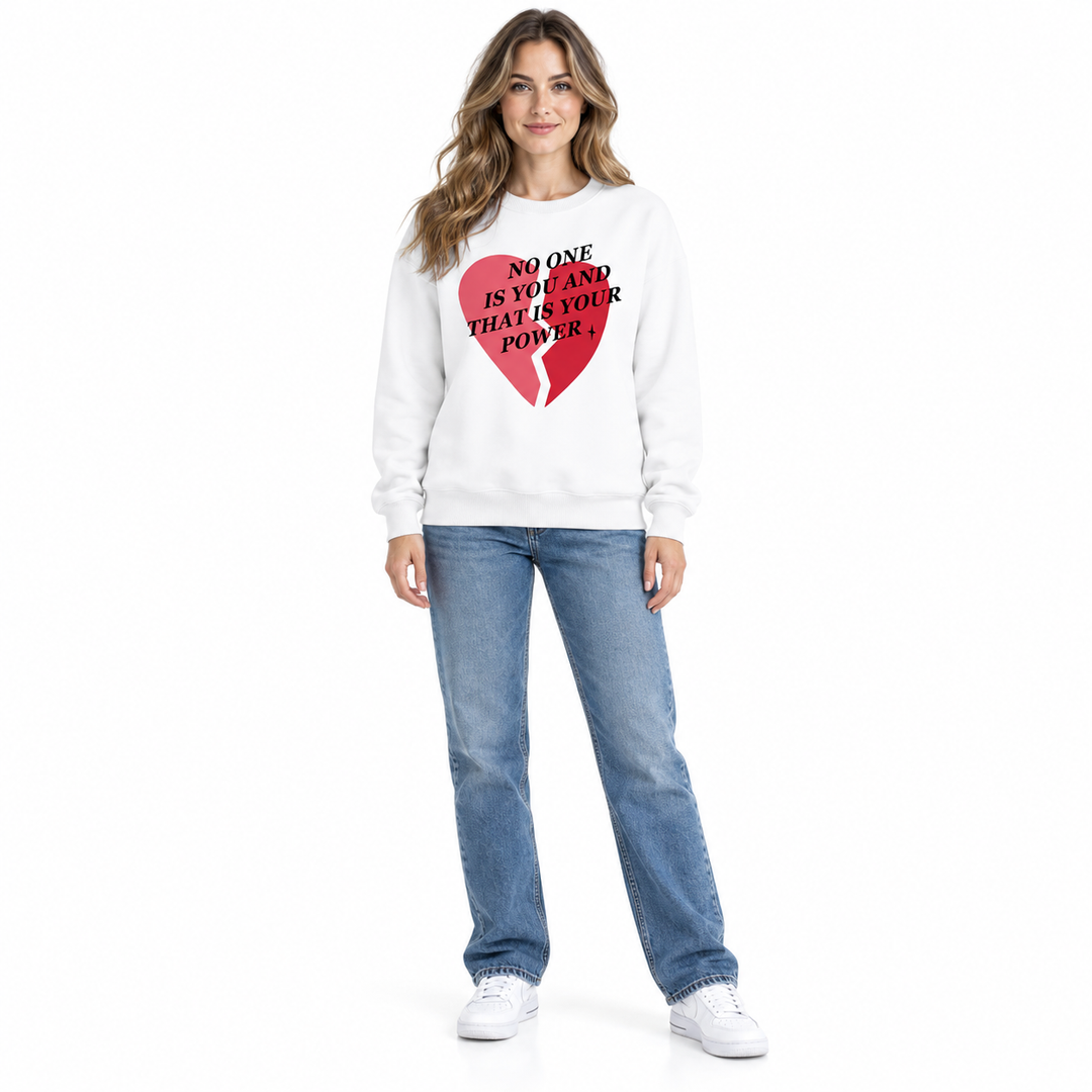 White heart sweatshirt on a full-length female model, showing the neckline, long sleeves and front print on a white backdrop.