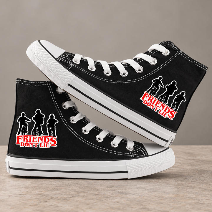 Black high-top sneakers, design 3, with the original side graphic on a warm gray studio background