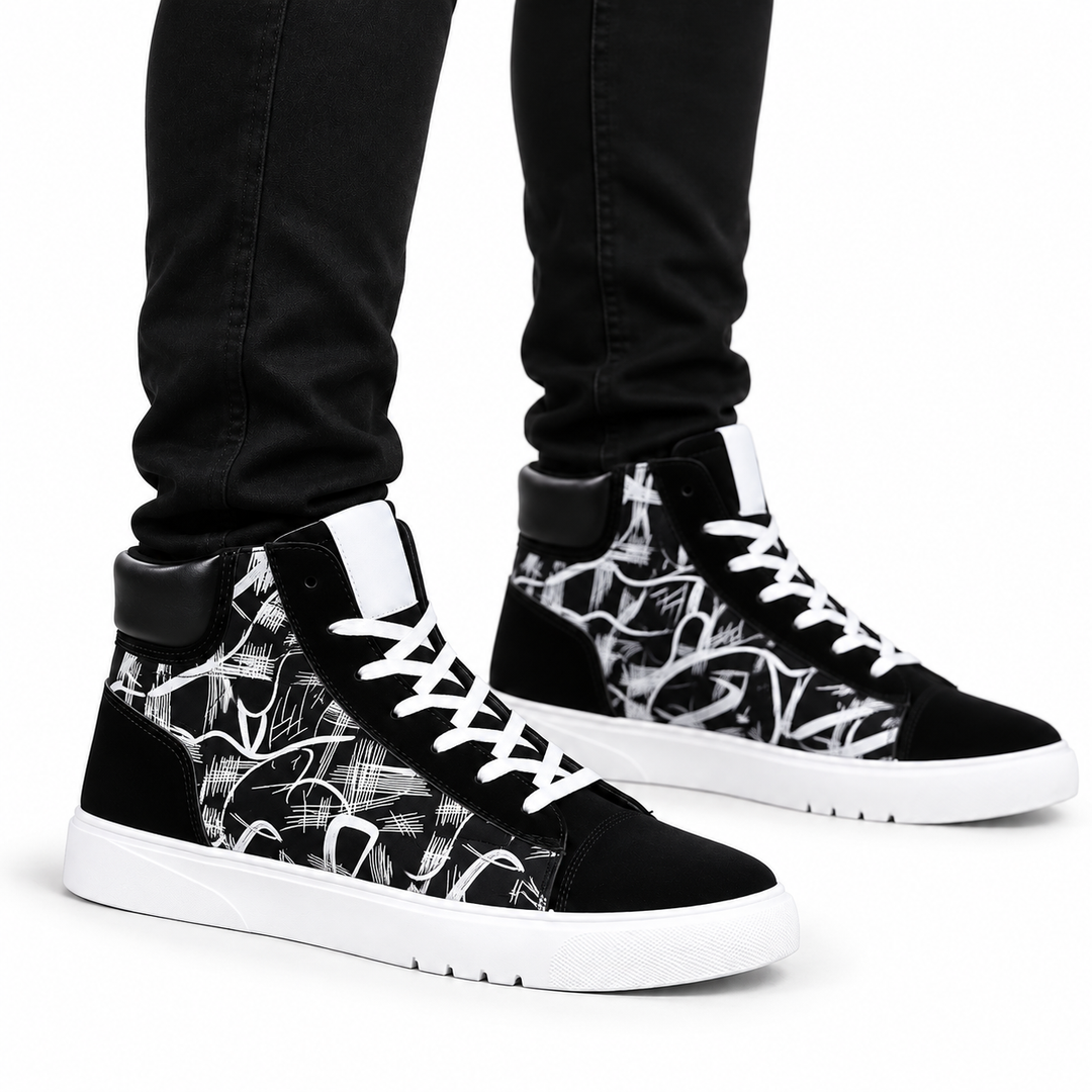 White graphic high top sneakers worn by a male model with black pants on a white background