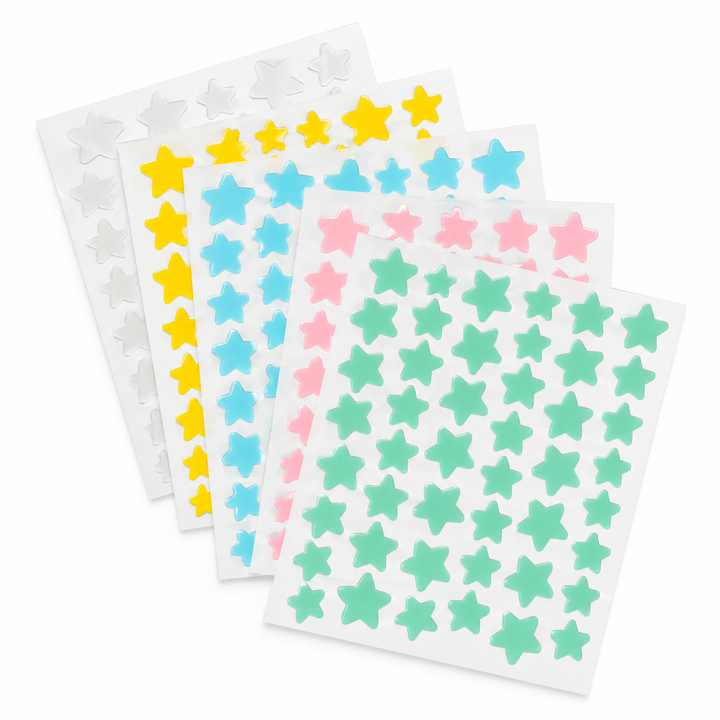 Fanned sheets of white, yellow, blue, pink and mint star-shaped patches photographed together against a white photo backdrop.