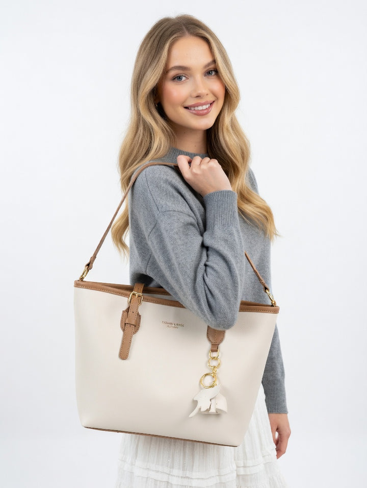 Woman holding a beige tote bag with a brand logo on a white background