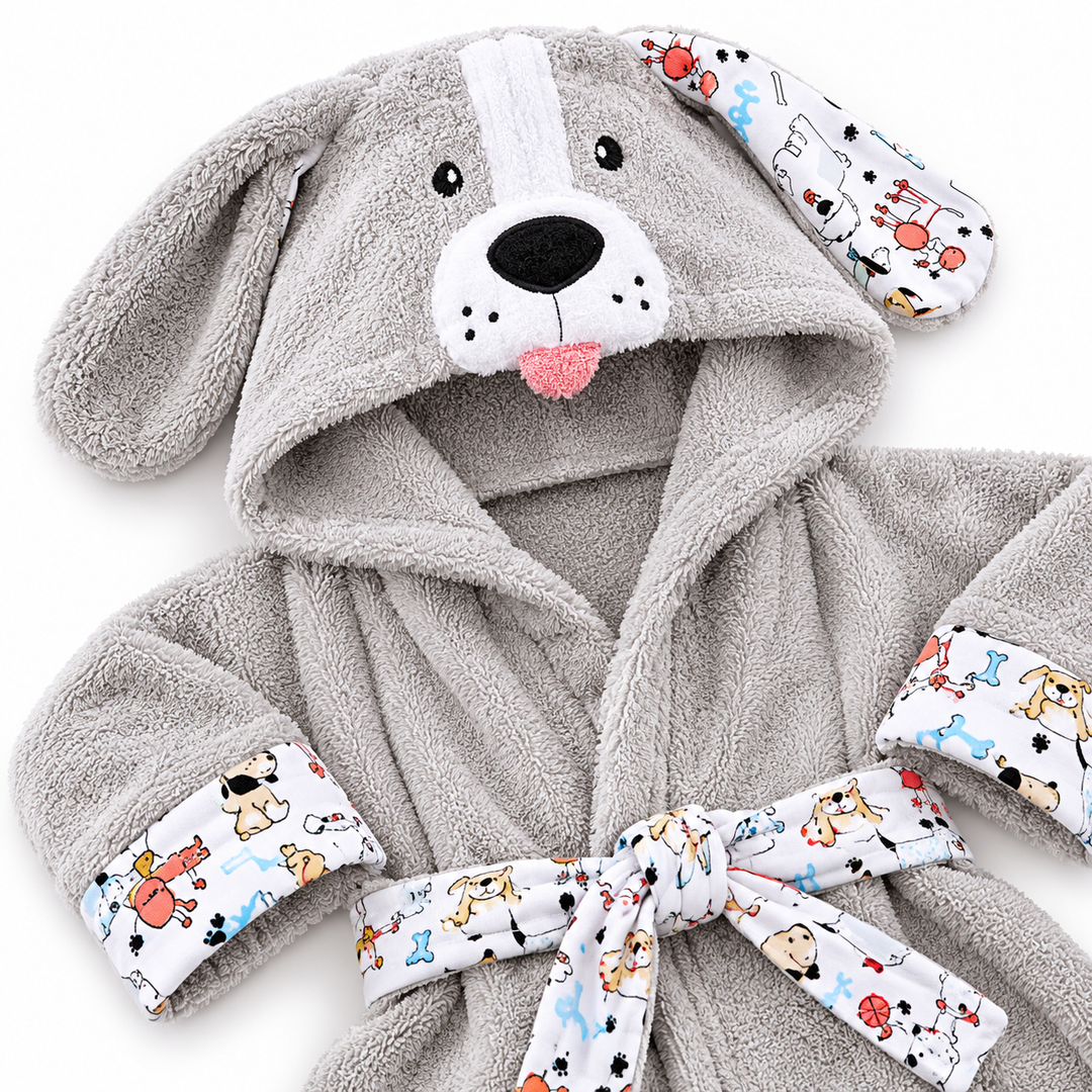Child standing in a light gray puppy animal hooded bathrobe, showing the printed cuffs, character hood and tied waist belt.