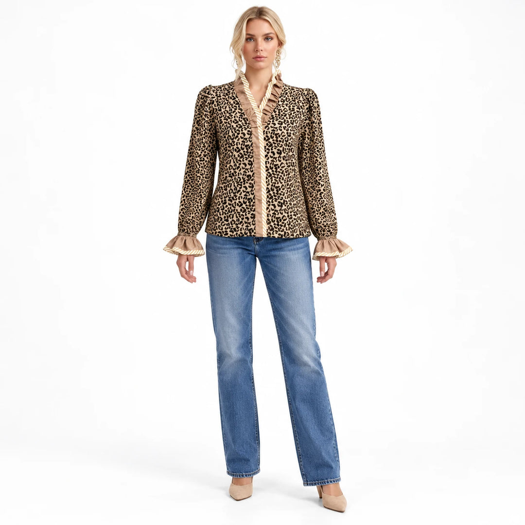 Wild Leopard Elegance blouse with beige ruffle neckline and cuffs, shown on an adult model in blue jeans in the white studio.