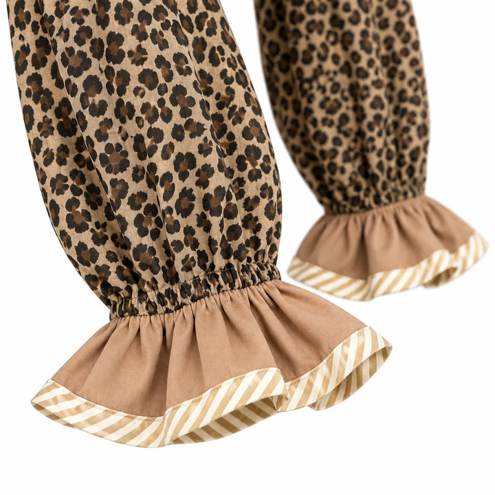 Detail of beige ruffled sleeve cuffs with cream striped edging and gathered leopard print sleeves against a white background.