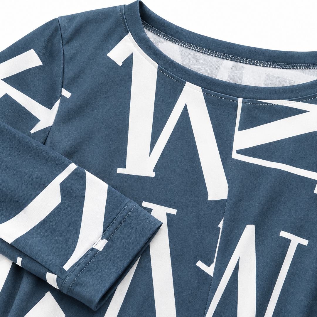 Close-up of the white letter pattern, sleeve cuff and fabric surface on the long sleeve dress.