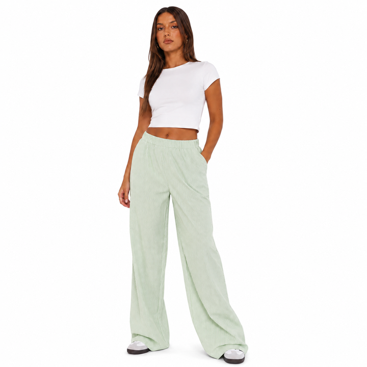 Light green wide leg pants for women on a studio model, showing elastic waist, subtle stripes and relaxed wide-leg silhouette.