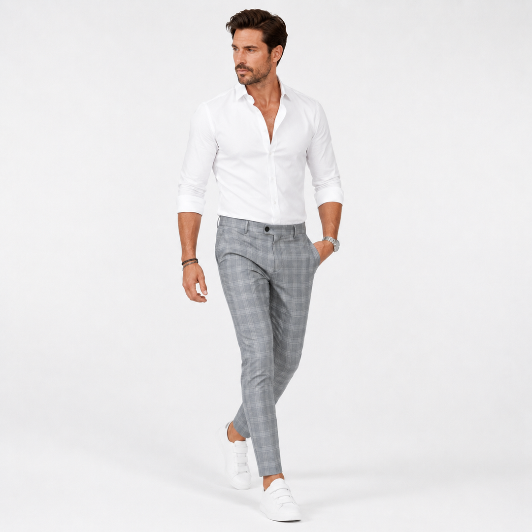 Light grey plaid trousers on an adult male model walking in a white studio to show fit, movement, and a natural fabric drape.