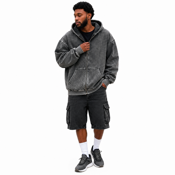 Washed charcoal zip hoodie on male model against a clean white studio background showing the garment color and washed finish.