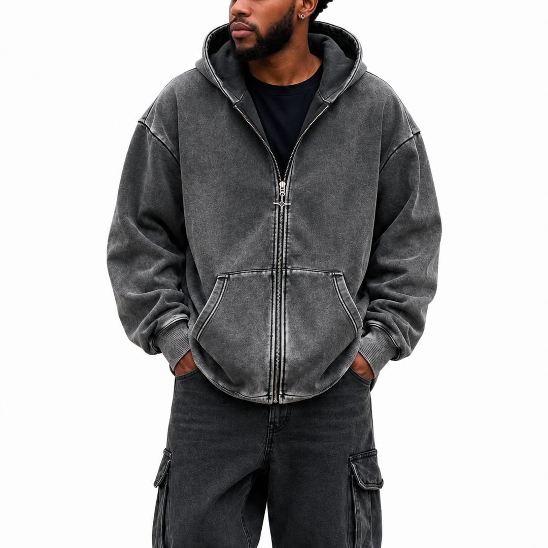 Front view of washed charcoal hoodie with full zipper, hood, divided front pocket, dropped shoulders and ribbed hem on white.