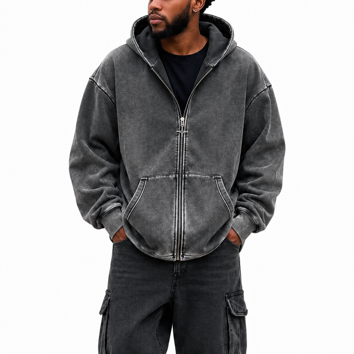 Front view of washed charcoal hoodie with full zipper, hood, divided front pocket, dropped shoulders and ribbed hem on white.