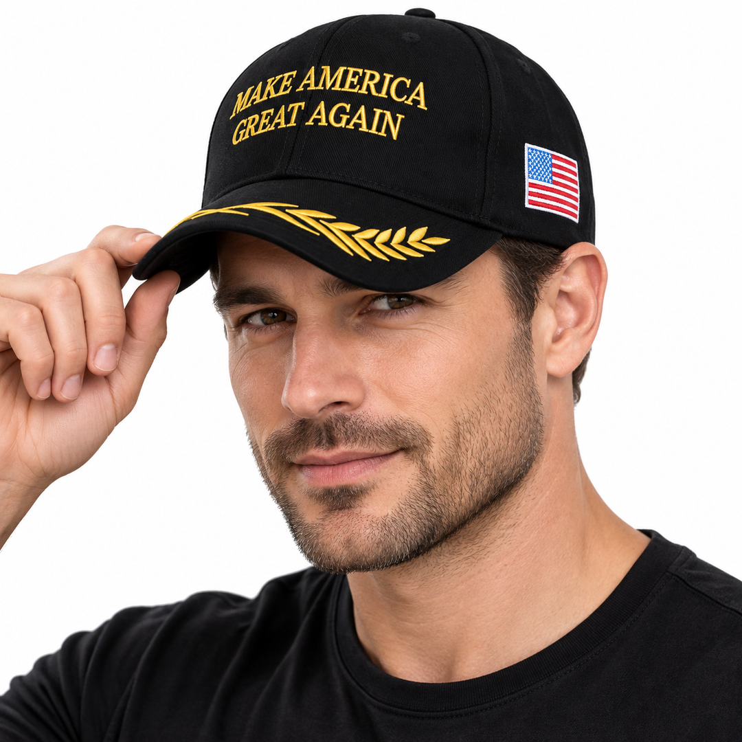 Male model wearing a black embroidered baseball cap with gold front lettering, gold brim detail and a US flag side patch.