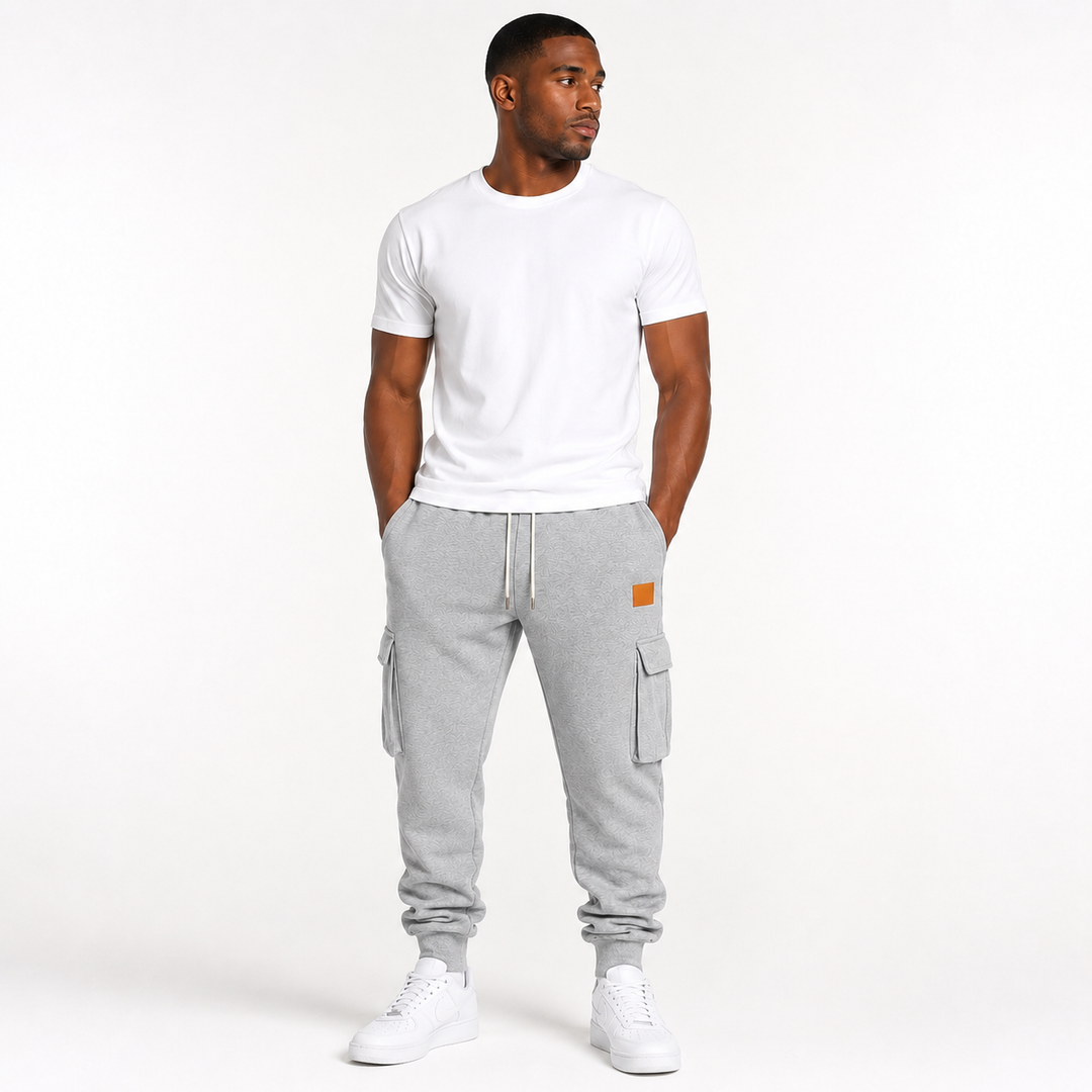 Male model wearing light gray cargo jogger pants in a clean commercial hero image on a white studio background.