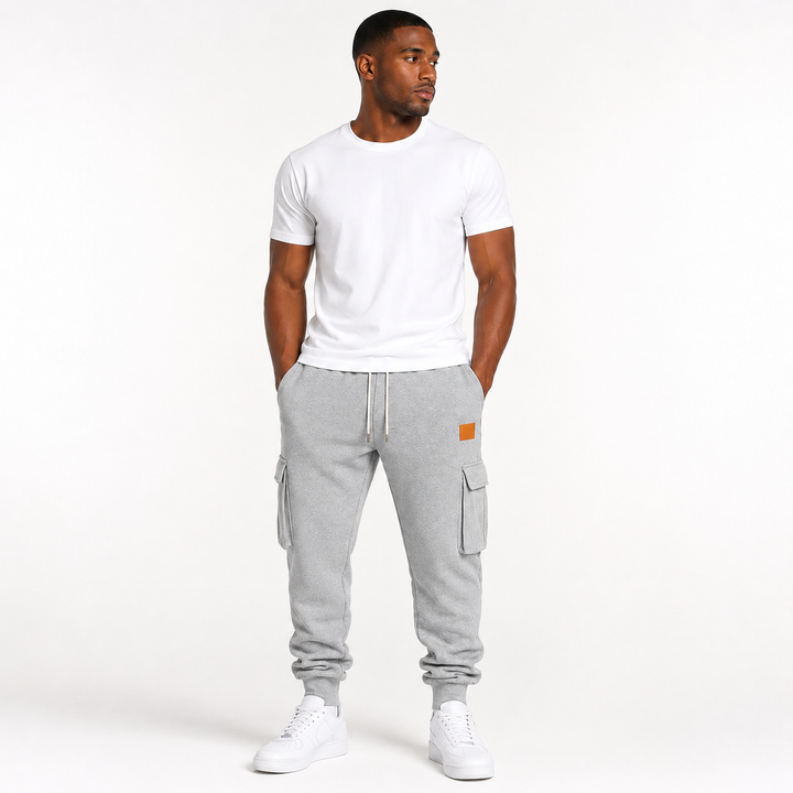 Male model wearing light gray cargo jogger pants in a clean commercial hero image on a white studio background.