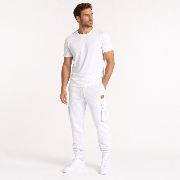 Male model wearing white cargo jogger pants in a minimalist lifestyle pose on a clean white studio background.