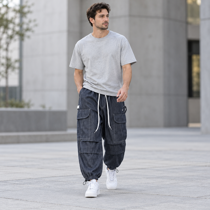 Full-body model walking in navy blue cargo joggers with contrast stitching and white drawstrings.