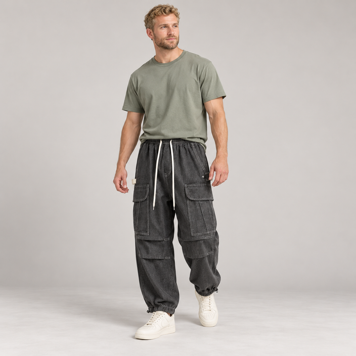Full-body model wearing black cargo joggers with flap pockets and contrast stitching.