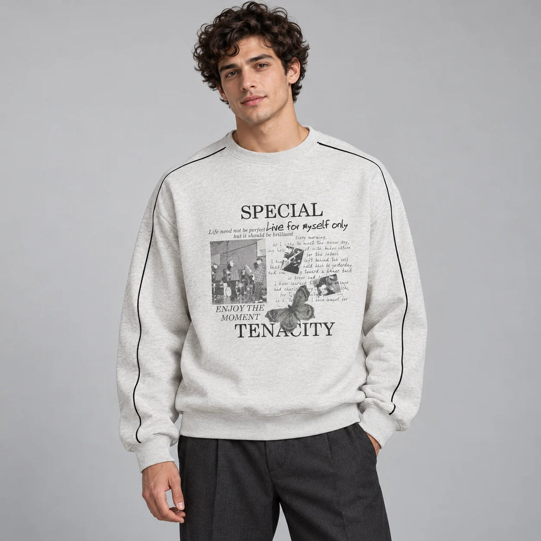Male model wearing the Modern Gray crewneck pullover with a printed front, dark sleeve lines and charcoal trousers in studio.