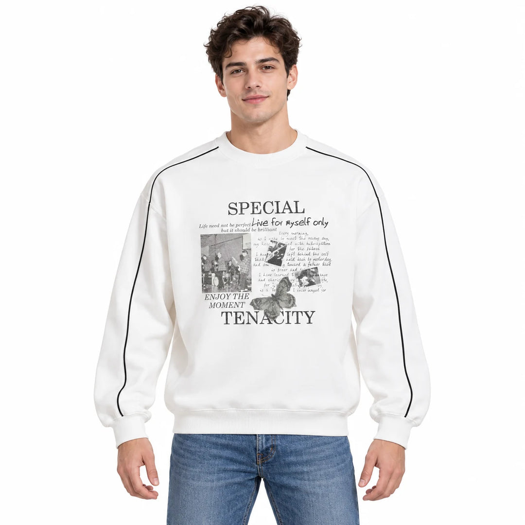 Male model wearing the Pearl White crewneck pullover with a printed front, dark sleeve lines and blue jeans in a white studio