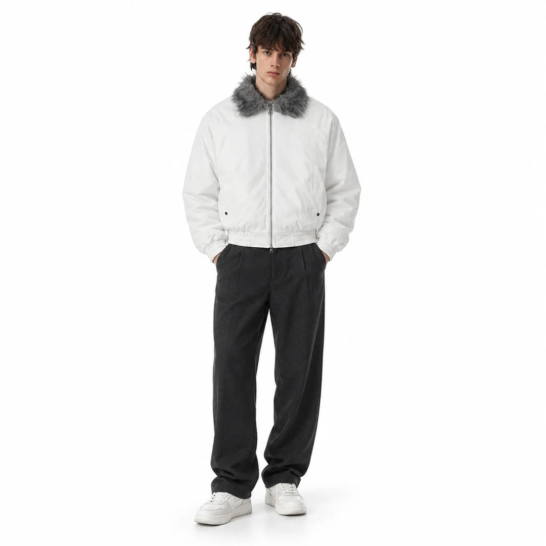 Male model wearing a white padded bomber jacket with a grey faux fur collar, dark wide-leg trousers and white shoes in studio