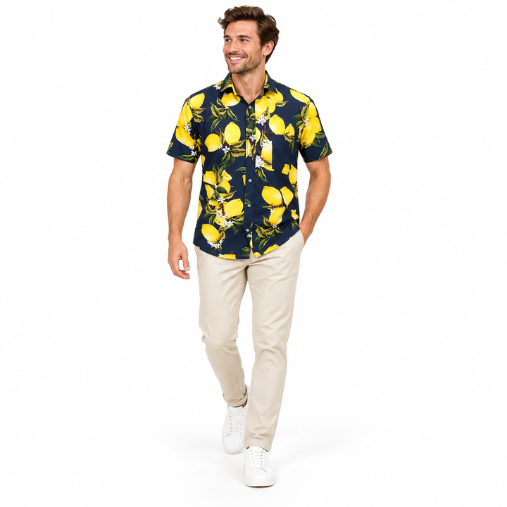 Model wearing a navy fruit print shirt walking with the printed garment and sleeves visible against a plain white background.